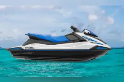 a blue and white boat sitting next to a body of water