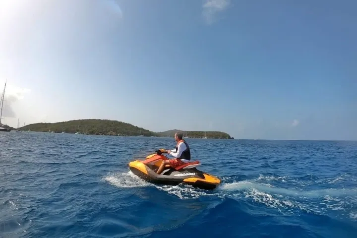 a man riding on the back of a boat in the water